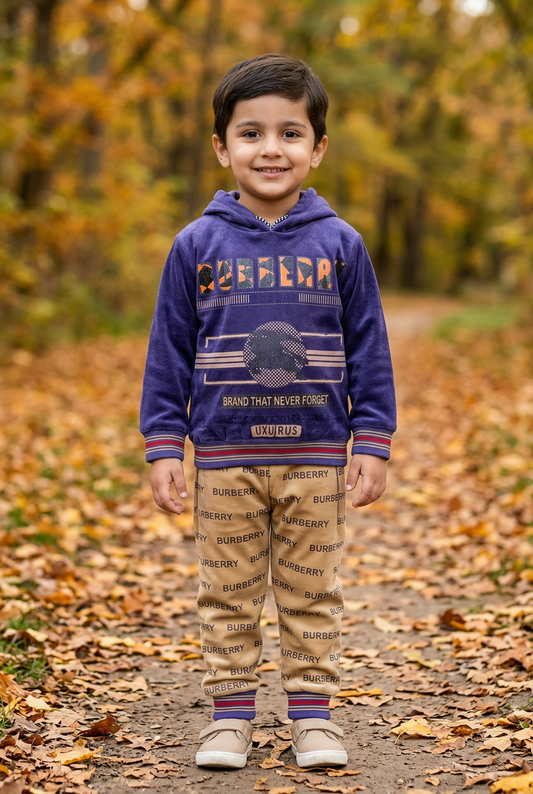 Child wearing BS815 blue-violet graphic fleece hoodie with striped trims and beige lettering-print joggers on an autumn park path.
