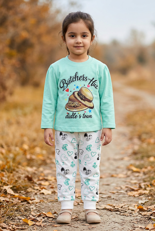 Girl wearing GS610 mint green hat-print top and white heart-print joggers on an autumn park path.