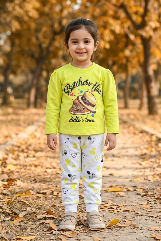 Girl wearing GS613 lime-yellow hat-print top and white joggers with yellow and black heart prints on an autumn park path.