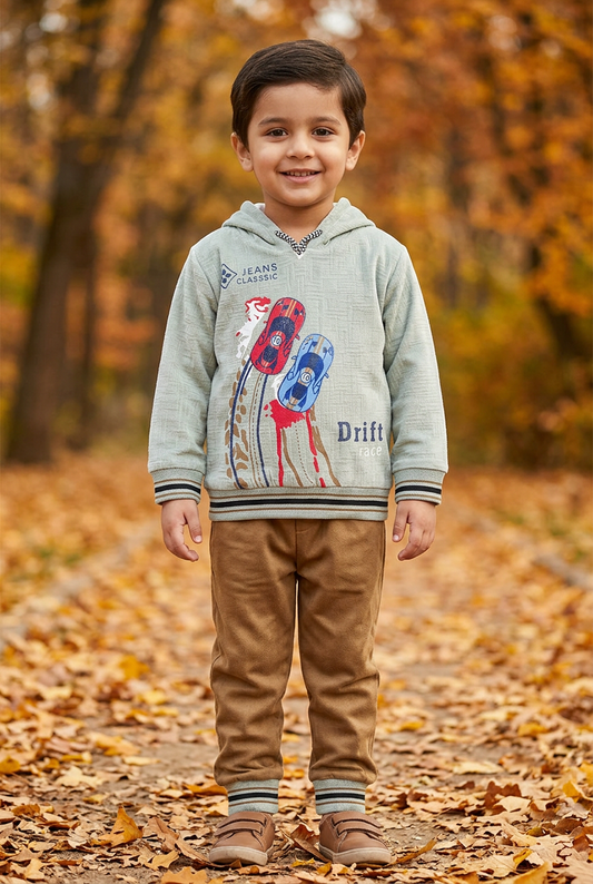Child wearing BS812 light sage-green racing-car fleece hoodie with striped trims and camel-brown joggers on an autumn park path.