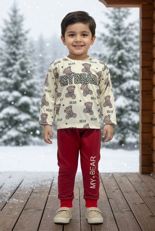 Child wearing BS795 cream checkerboard-bear Terry sweatshirt and deep-red MY BEAR joggers on a sheltered veranda with snowy pine trees behind