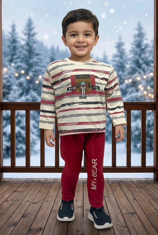 Child wearing BS790 cream brushstroke-striped Terry top with bear chest detail and red MY BEAR joggers on a veranda overlooking snowy pines