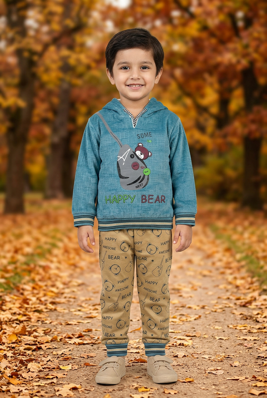 Child wearing BS817 blue textured Happy Bear fleece hoodie with striped trims and beige bear-print joggers on an autumn park path.