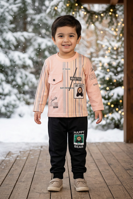 Child wearing BS829 light-peach striped Terry top with chest pocket and bear detail, and black bear-patch joggers on a veranda beside snowy pines.