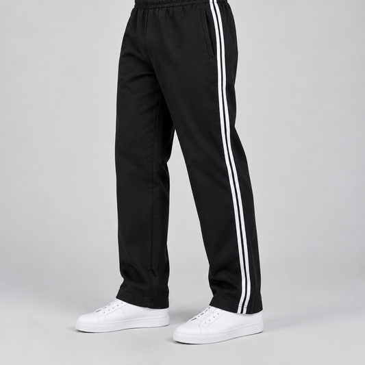 Man wearing black MT250 casual trousers with double white side stripes and white sneakers, cropped to legs and feet