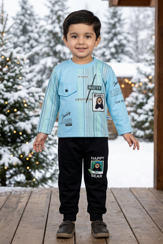 Child wearing BS831 sky-blue striped Terry top with chest pocket and bear detail, and black bear-patch joggers on a veranda beside snowy pines.